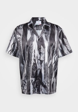 Short-sleeve button-up shirt in black and white with a textured snake pattern, featuring a relaxed collar and smooth fabric finish.