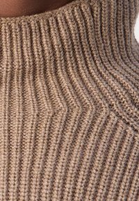 Brauner, gerippter Strick-Turtleneck mit einem strukturierten, geschichteten Muster und vertikalen Linien, das das weiche, warme Material hervorhebt.