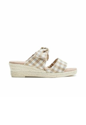 Sandalia de cuña beige y blanca a cuadros con dos tiras de tela, una anudada en forma de lazo, y una suela tejida estilo esparto.