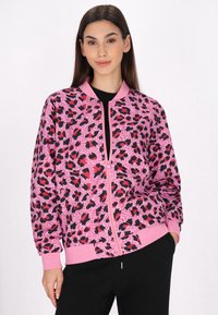 Giacca bomber rosa con stampa leopardata nera e rossa, con chiusura con zip e polsini e orlo a coste, realizzata in un tessuto leggero e liscio.