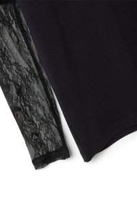 Schwarzes Oberteil mit figurbetontem Oberteil und langen, transparenten schwarzen Spitzenärmeln, die ein florales Muster und eine wellenförmige Spitzenkante am Ärmelabschluss aufweisen.