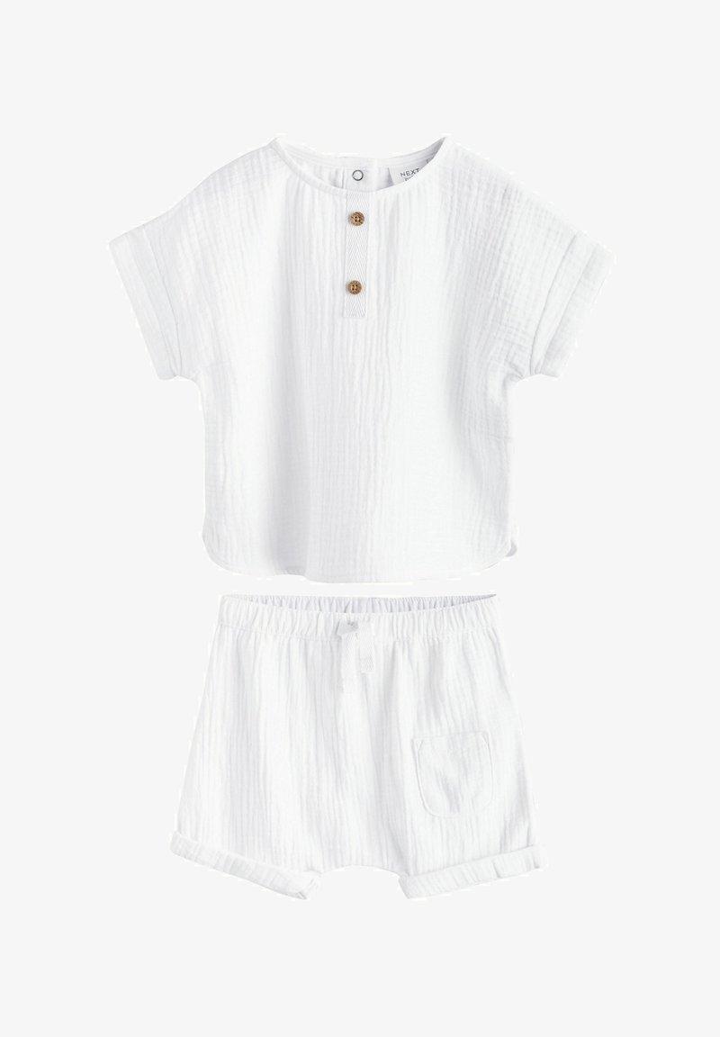 Chemise bébé blanche à manches courtes texturée avec deux boutons en bois et shorts assortis à taille élastique avec poche avant et revers roulés.