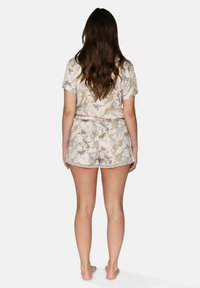 Set de pijamale cu mânecă scurtă, având un model floral pastelat. Fabricat dintr-un material moale, cu un tiv ondulat pe pantaloni scurți și un design ușor și aerisit.