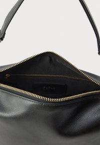 Μαύρη δερμάτινη τσάντα χειρός με υφή, κλείσιμο με φερμουάρ και χρυσούς μεταλλικούς μηχανισμούς φερμουάρ. Στο εσωτερικό διαθέτει ετικέτα με λογότυπο και τσέπη.