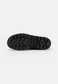 Suela de zapato de goma negra con un patrón de tread robusto, con lóbulos de tracción, varios orificios de drenaje y superficie texturizada para un mejor agarre.