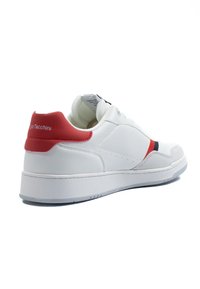 Sneaker bianca con tallone rosso e accenti neri, caratterizzata da una tomaia in pelle liscia, colletto imbottito e suola in gomma testurizzata.