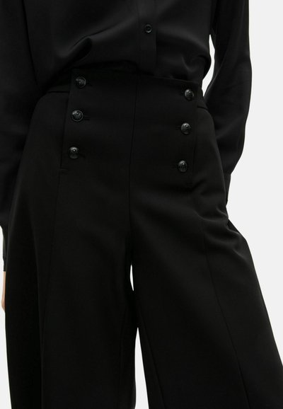 Pantaloni neri sartoriali a vita alta con gambe ampie, dotati di sei bottoni decorativi sul davanti e una texture del tessuto liscia.