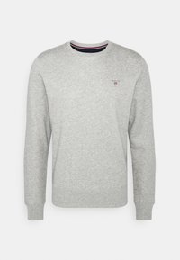 Sweat-shirt gris clair à col rond, manches longues, poignets et ourlet côtelés, avec un petit logo brodé sur la poitrine gauche.