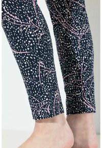 Leggings de color navy con un patrón de manchas y ramas blancas y rosas. Material suave con un diseño ajustado, que termina justo por encima del tobillo.