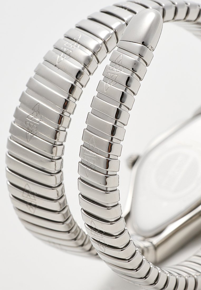 Montre en acier inoxydable avec un bracelet flexible comportant des maillons rectangulaires, des détails gravés et une forme de boîtier arrondie. Fini lisse et poli.