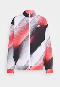 Adidas track jacket featuring a zippered front, high collar, and a pattern of red, black, and white diagonal stripes. Lightweight fabric.