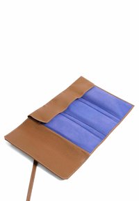 Bolsita de cuero marrón con un exterior texturizado. El interior cuenta con tres compartimentos de ante azul. Cierre con solapa.