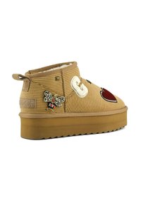 Stivale alla caviglia in velluto a coste marrone con fodera peluche, decorato con una toppa a forma di ape e un dettaglio a cuore, con suola spessa color tan e tomaia testurizzata.