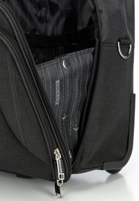 Borsa in tessuto nero con zip, con un interno a motivo. Decorazioni includono un cursore in metallo argento e un anello laterale.