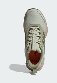 Lichtgroene sportschoen met een gestructureerd bovenwerk, vastgezette veters, oranje binnenzool en rubberen zool. Voorzien van logo en trekzoom bij de hiel.