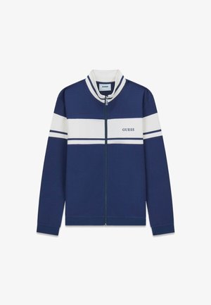Veste zippée bleu marine avec des rayures horizontales blanches et le logo "GUESS" sur la poitrine, poignets et col côtelés avec des accents blancs et bleus.