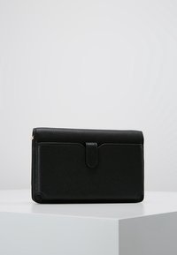 Billetera de cuero negro con superficie texturizada, forma rectangular, cierre de solapa y detalle de costura en contraste. Diseño compacto y funcional.