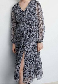 Zwarte bloemen wikkeljurk van doorschijnende stof, met lange mouwen, een diepe V-hals, een getailleerde taille en een zijsplit.