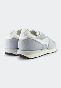 Sneaker in camoscio grigio con dettagli in pelle bianca, caratterizzati da un logo discreto sul tallone, suola in gomma e elementi di design texturizzati.