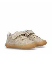 Sneakers in tessuto beige con una finitura testurizzata, dotati di una chiusura in velcro e dettagli in pizzo, e una suola in gomma marrone chiaro.