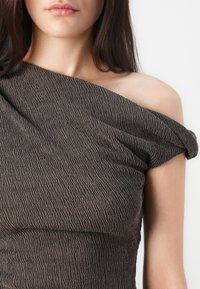 Brown textured off-the-shoulder top with a wrinkled fabric design, featuring a wide neckline and draped detailing.