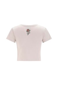 Lys pink cropped T-shirt med korte ærmer og et lille broderet rødt og grønt rosemønster centreret nær halsudskæringen på ryggen.