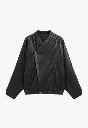 Giacca in pelle nera con texture, maniche larghe, chiusura frontale asimmetrica con bottoni a pressione e cuciture ben visibili.