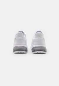 Bílé sportovní boty s texturovaným síťovaným svrškem, polstrovaným límcem a viditelnou vzduchovou bublinou v šedé podrážce. Obsahují poutko na patě.