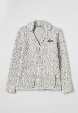 Jasnoszary sweter kardigan z dzianiny z kołnierzem, czterema guzikami z przodu, dwoma naszywanymi kieszeniami oraz ciemną, wzorzystą chusteczką w kieszeni na piersi.