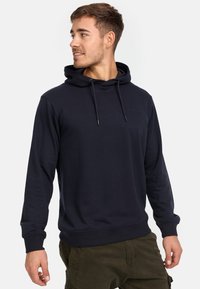 Mørkeblå pullover hoodie med snor i huen, ribbede manschetter og kant, med et lille logo på brystet og en glat tekstur.