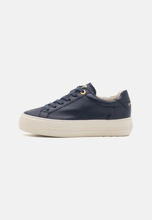Baskets en cuir bleu marine avec surface texturée, bout rond, semelle en caoutchouc crème et œillets dorés pour les lacets. Marquage subtil sur le talon.
