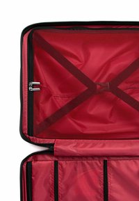 Vnitřní části červeného cestovního vaku obsahují síťované kapsy, kapsy na zip a hladkou látkovou podšívku s designem křížových popruhů pro lepší organizaci.