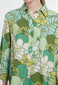 Långärmad skjorta i grön och blå blommönster, med krage, knapplist och lätt, slät tyg.