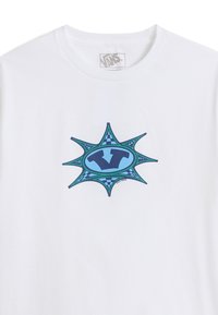 Vit bomullströja med en blå och grön grafisk design som har en stjärnform och en central "V"-logotyp, omgiven av ett rutigt mönster.