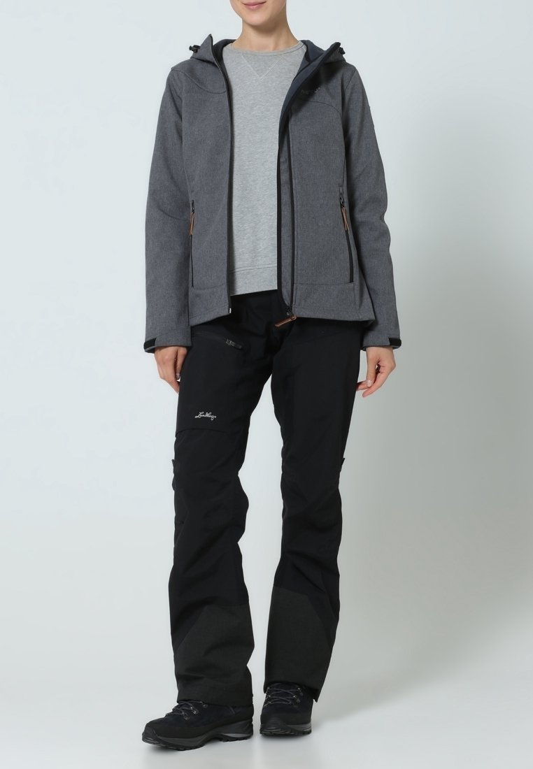 Veste grise à fermeture éclair avec capuche, dotée de deux poches avant et d'accents noirs. Pantalon noir avec détail logo et panneaux gris foncé contrastants. Bottes noires.