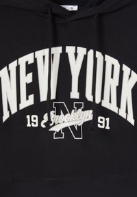 Czarny sweter z kapturem, zdobiony białym napisem "NEW YORK" oraz "Brooklyn" wykonanym kursywą. Posiada sznurki do regulacji i ściągacz u dołu.