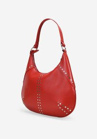Bolso de hombro de cuero rojo con forma curva. Presenta tachuelas plateadas a lo largo de las costuras y una sola correa con herrajes metálicos. Textura suave.