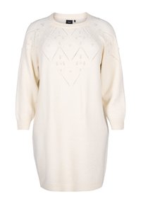 Kermanvärinen neulemekko, jossa on rento istuvuus, esittelee timanttikuvioita ja teksturoituja yksityiskohtia. Pyöreä pääntie ja pitkät hihat.