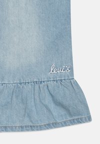 Ljusblå denimkjol med volangnederdel. Har vit "levi's" broderad logotyp. Mjuk textur med synliga sömnadsdetaljer.