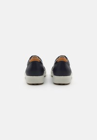 Navy blue leather shoes with a smooth texture, featuring a light gray sole and tan heel accents, designed with a low profile.