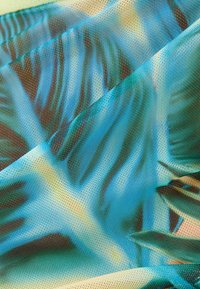 Multicolore textiel met een bladdessin in tinten blauw en groen, met een fijne, gestructureerde, netachtige oppervlakte en een lichte glans.