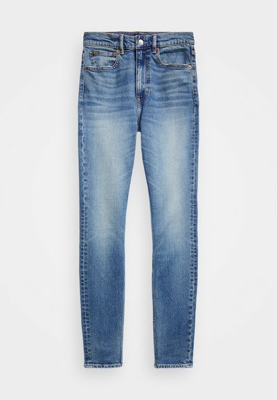 Light blue denim jeans with a slim fit, faded wash, five pockets, and button closure. Detailed stitching along the seams.