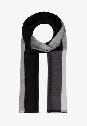Écharpe rectangulaire à blocs de couleurs noir, gris foncé et gris clair avec bords frangés, pliée en boucle sur un fond blanc.