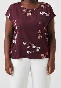 Bordeaux bloemenblouse met korte mouwen, voorzien van witte en roze bloemen, gemaakt van zachte, gladde stof. Gekocht met lichtgekleurde broeken.