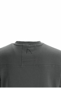 Maglietta sportiva grigia scura con tessuto testurizzato, scollatura a girocollo e un dettaglio di cucitura distintivo sul retro con un piccolo accento di logo.