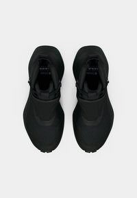 Black athletic shoes with a sleek design, featuring a textured mesh upper, padded collar, and a rounded toe. Lightweight, minimal hardware.