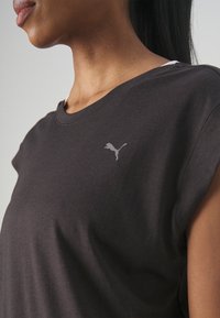 Tumesinine, lühikeste varrukatega T-särk, mis on valmistatud pehmest kangast. Rinna peal on väike heledam hall Puma logo ja särk on veidi lõdva lõikega.