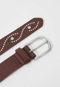Brown faux leather belt with silver round studs and rhinestone accents. Features a rectangular silver metal buckle.