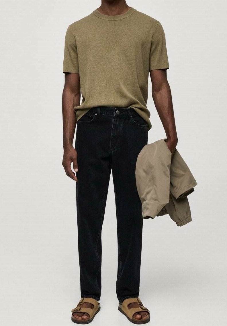 Camisa de punto de manga corta, vaqueros de mezclilla oscuros, chaqueta ligera beige y sandalias marrones. Diseño sencillo, ajuste informal, sin patrones visibles.