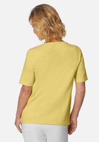 Gelbes T-Shirt mit kurzen Ärmeln und rundem Halsausschnitt, aus glattem Material. Die Rückansicht zeigt eine lässige Passform und ein nahtloses Design.